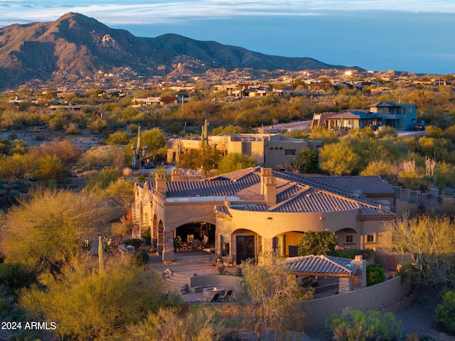 rear view of house with a patio area, stucco siding, a mountain view, and a tile roof