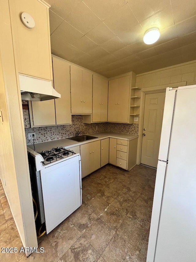 kitchen with cream cabinetry, white appliances, tasteful backsplash, and sink