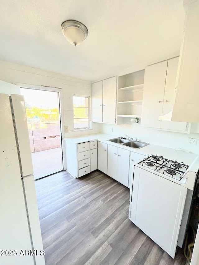 kitchen featuring sink, white cabinets, and white appliances