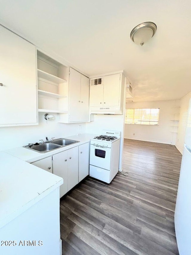 kitchen with dark hardwood / wood-style flooring, white cabinetry, gas range gas stove, and sink