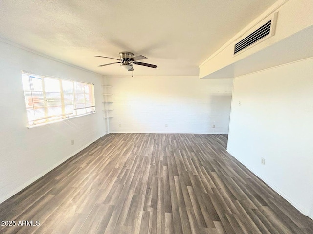 spare room with ceiling fan and dark wood-type flooring