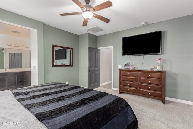 bedroom featuring ensuite bath, light carpet, sink, and ceiling fan