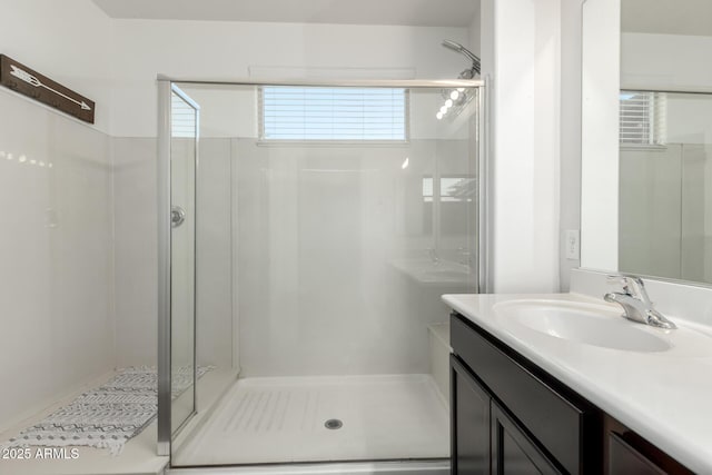 bathroom with a shower with shower door and vanity