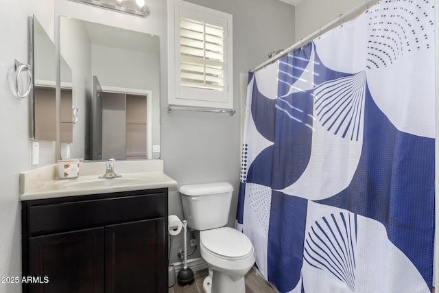 bathroom with toilet, a shower with shower curtain, and vanity