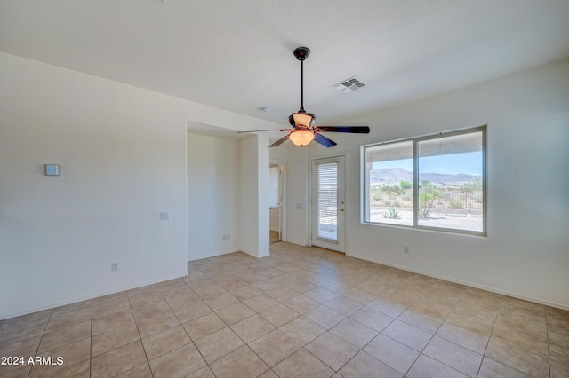 tiled spare room featuring ceiling fan