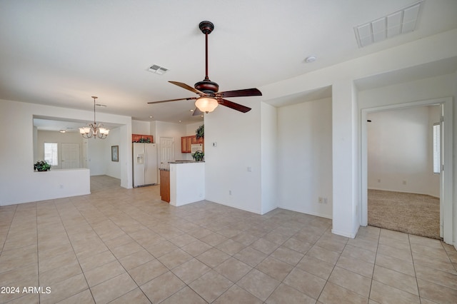 empty room featuring light tile floors and ceiling fan with notable chandelier