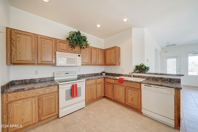 kitchen featuring sink, kitchen peninsula, white appliances, and light tile floors