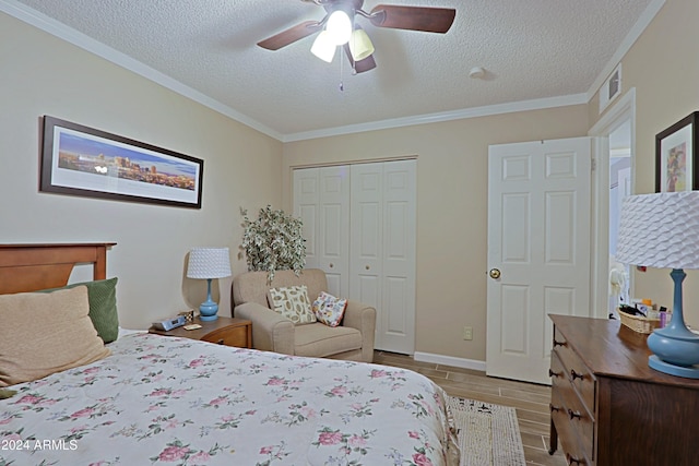 bedroom with ceiling fan, a closet, crown molding, and a textured ceiling