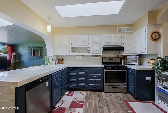 kitchen with white cabinets, stainless steel appliances, hanging light fixtures, and sink