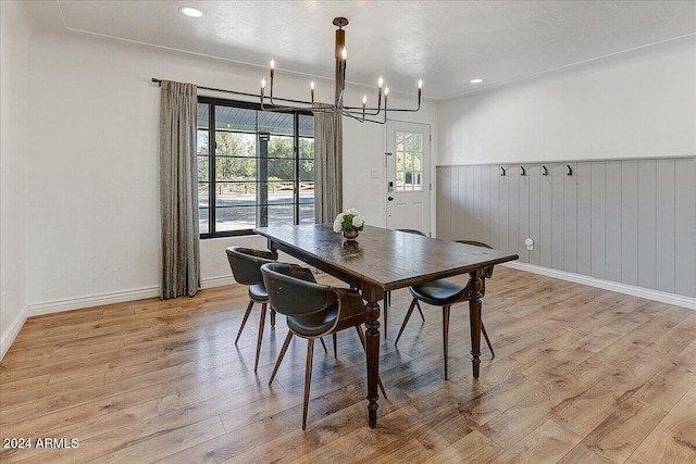 dining area with a notable chandelier and light hardwood / wood-style floors