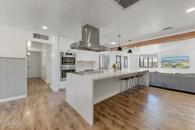 kitchen featuring extractor fan, light hardwood / wood-style flooring, white cabinetry, and stainless steel appliances