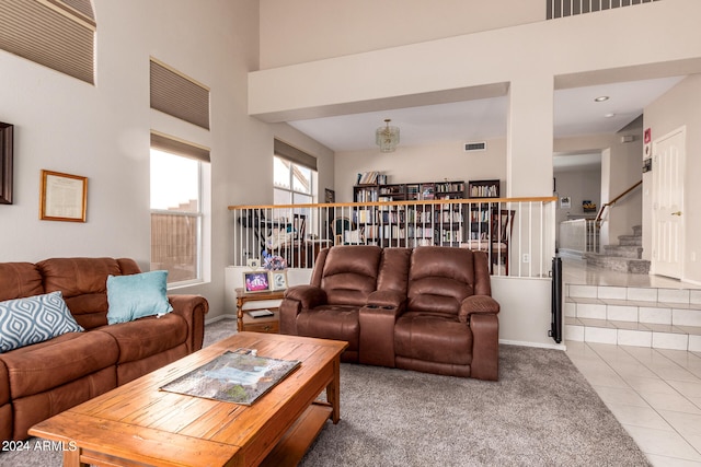 living room featuring a towering ceiling and tile patterned flooring