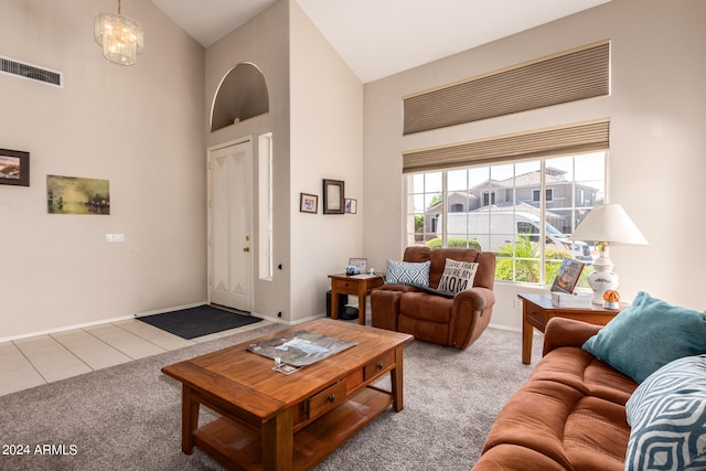 living room featuring a notable chandelier, light carpet, and high vaulted ceiling