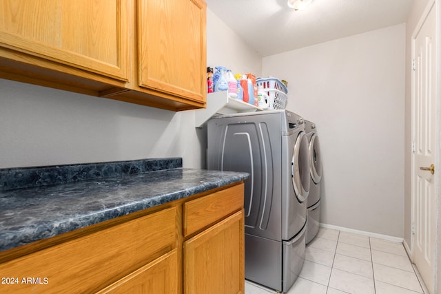 laundry room with cabinets, independent washer and dryer, and light tile patterned flooring