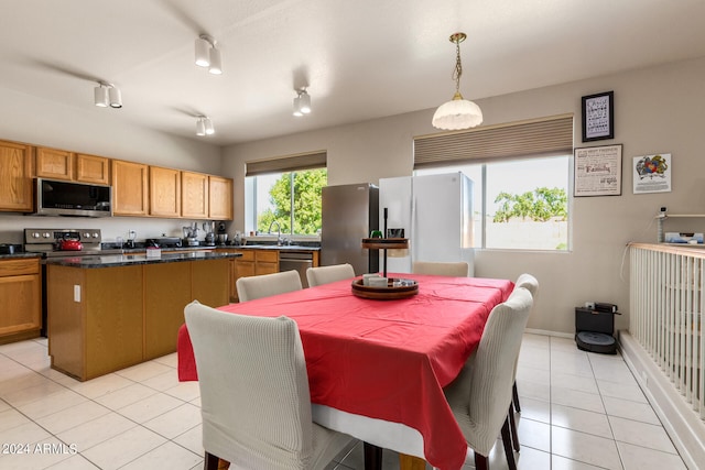 tiled dining area with track lighting and sink