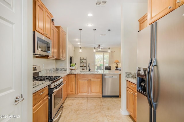 kitchen with kitchen peninsula, light stone countertops, stainless steel appliances, ceiling fan, and sink