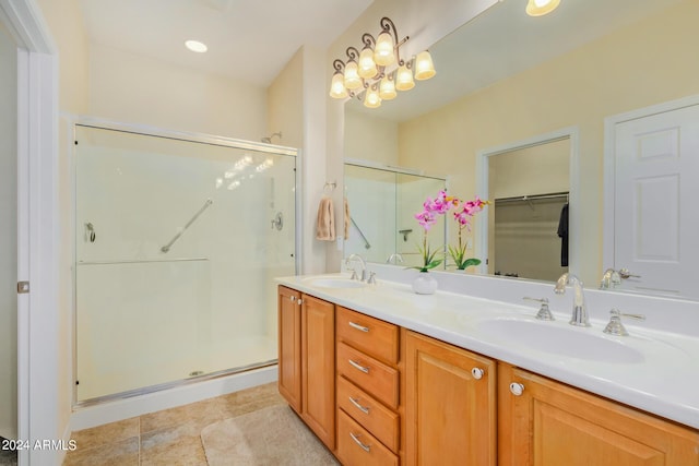 bathroom featuring tile patterned flooring, vanity, an enclosed shower, and a chandelier