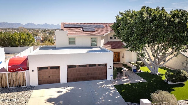 view of front of house with a mountain view, a garage, and solar panels