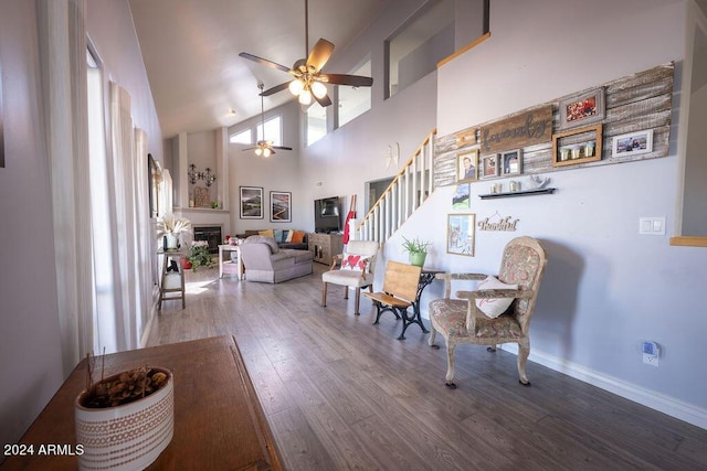 interior space featuring ceiling fan, wood-type flooring, and a high ceiling