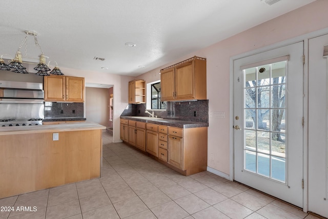 kitchen featuring sink, tasteful backsplash, stainless steel gas cooktop, and light tile patterned flooring