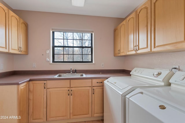 laundry room with washer and clothes dryer, sink, and cabinets