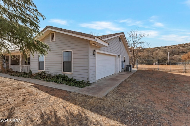 view of home's exterior with a garage and central AC unit