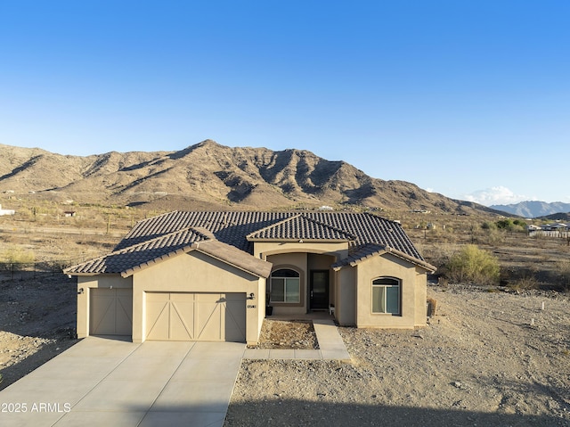 10540 S 32nd Dr, Laveen, AZ 85339 - view of front of house featuring a garage, a mountain view, concrete driveway, stucco siding, and a tile roof