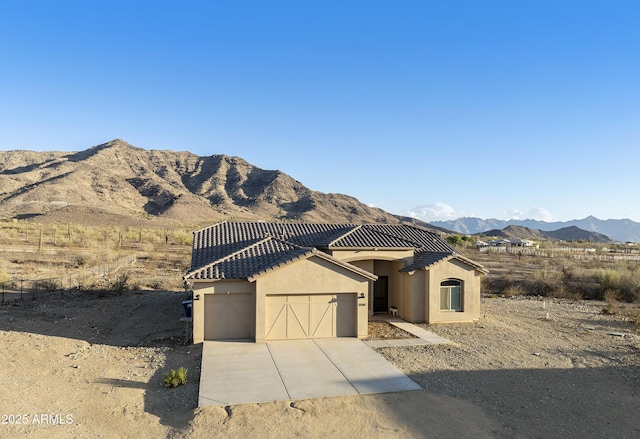10540 S 32nd Dr, Laveen, AZ 85339 - view of front facade featuring an attached garage, a mountain view, stucco siding, a tiled roof, and driveway