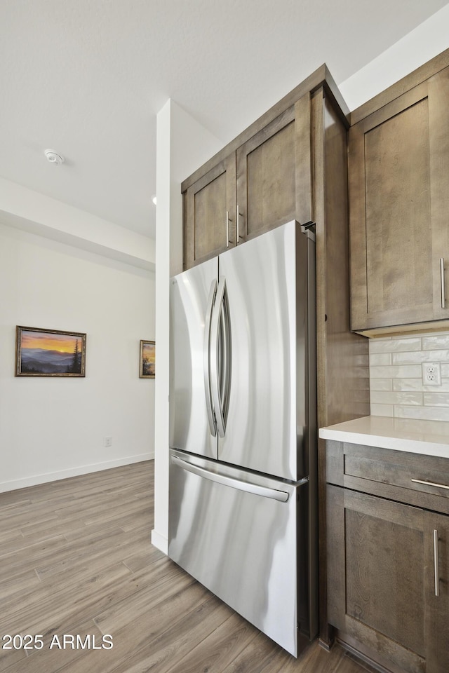 10540 S 32nd Dr, Laveen, AZ 85339 - kitchen featuring freestanding refrigerator, light wood-style floors, decorative backsplash, light countertops, and baseboards