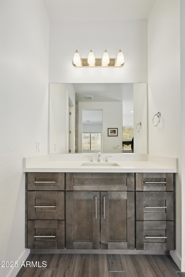 10540 S 32nd Dr, Laveen, AZ 85339 - bathroom featuring vanity, wood finished floors, and baseboards
