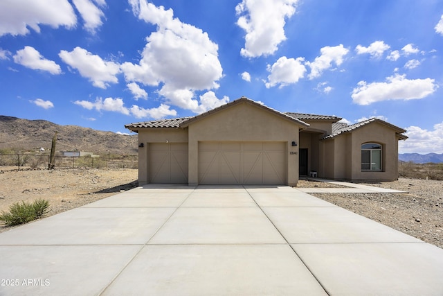 10540 S 32nd Dr, Laveen, AZ 85339 - mediterranean / spanish home featuring a mountain view, an attached garage, stucco siding, and driveway