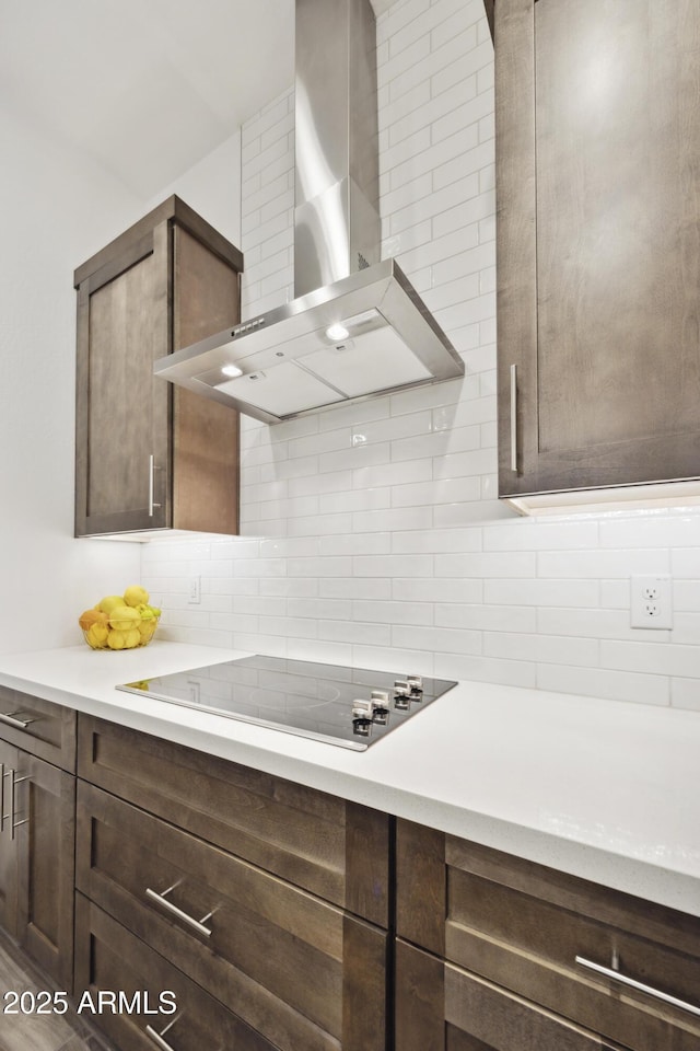 10540 S 32nd Dr, Laveen, AZ 85339 - kitchen featuring wall chimney range hood, black electric cooktop, dark brown cabinetry, and tasteful backsplash