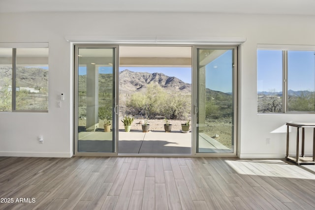 10540 S 32nd Dr, Laveen, AZ 85339 - doorway with wood finished floors, a mountain view, baseboards, and plenty of natural light