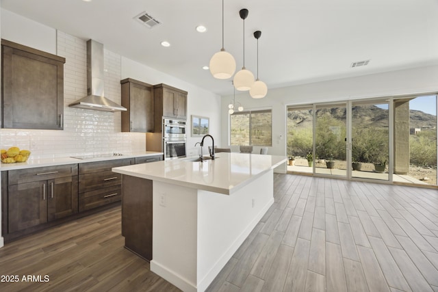 10540 S 32nd Dr, Laveen, AZ 85339 - kitchen with wall chimney exhaust hood, a sink, dark wood-style floors, recessed lighting, and stainless steel double oven