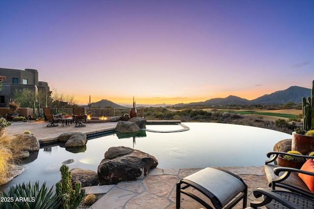 view of pool featuring fence, a mountain view, and a patio