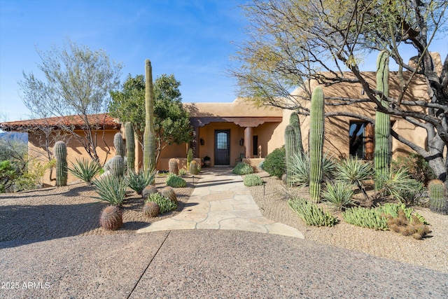 pueblo-style house featuring stucco siding