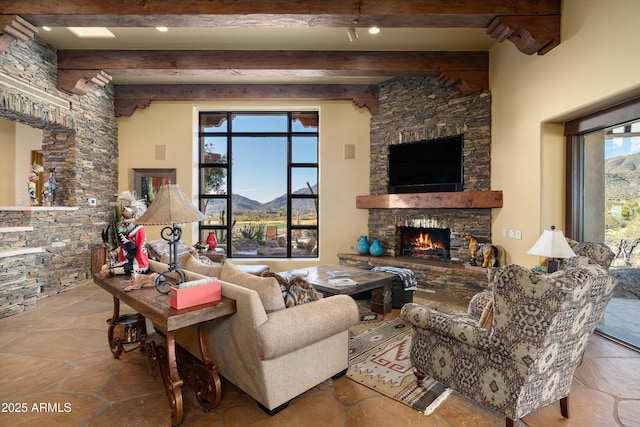 living room with stone tile floors, a fireplace, and beamed ceiling