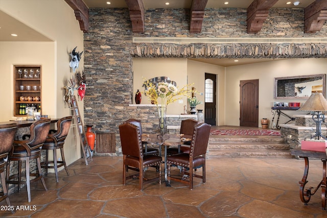 dining space with recessed lighting, stone tile flooring, beamed ceiling, and a bar