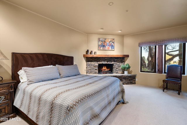 bedroom with carpet flooring and a stone fireplace