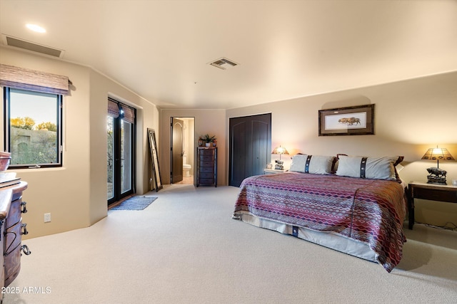 bedroom with light carpet, ensuite bath, and visible vents