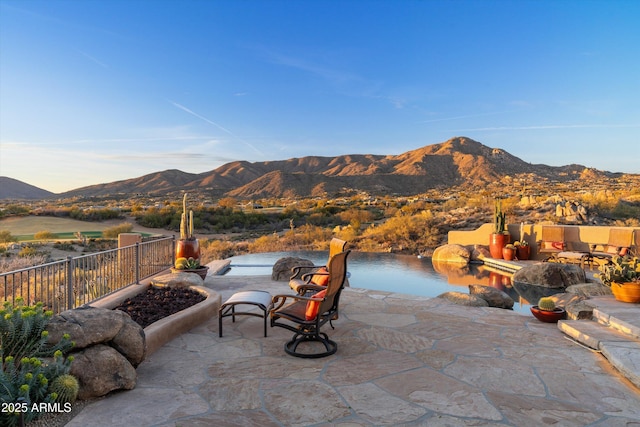 view of patio / terrace featuring fence and a mountain view