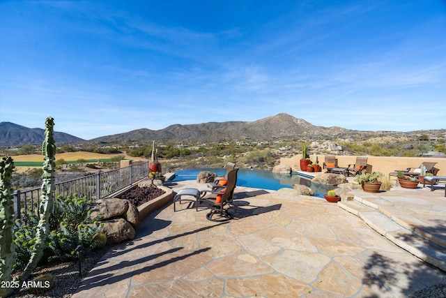 view of patio with a mountain view and fence