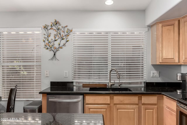 kitchen featuring light brown cabinetry, stainless steel appliances, dark stone countertops, and sink