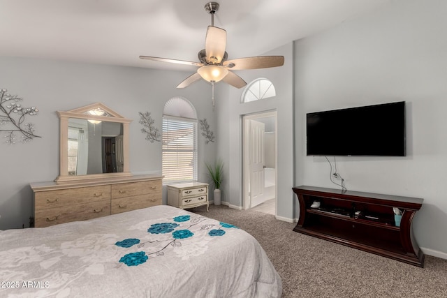 bedroom with ceiling fan, light colored carpet, and ensuite bath