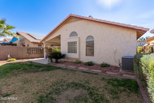 rear view of property with cooling unit and a yard