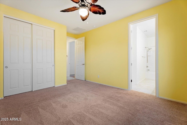 unfurnished bedroom with ensuite bathroom, light colored carpet, ceiling fan, and a closet