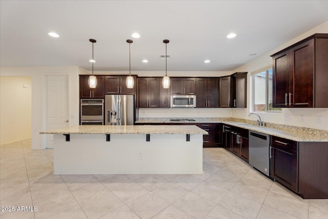 kitchen with pendant lighting, stainless steel appliances, a center island, and a breakfast bar area