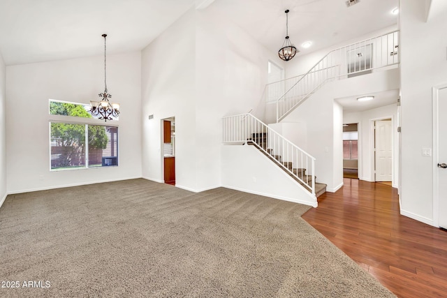 664 E Windsor Dr, Gilbert, AZ 85296 - unfurnished living room with a chandelier, high vaulted ceiling, stairs, baseboards, and dark wood-type flooring