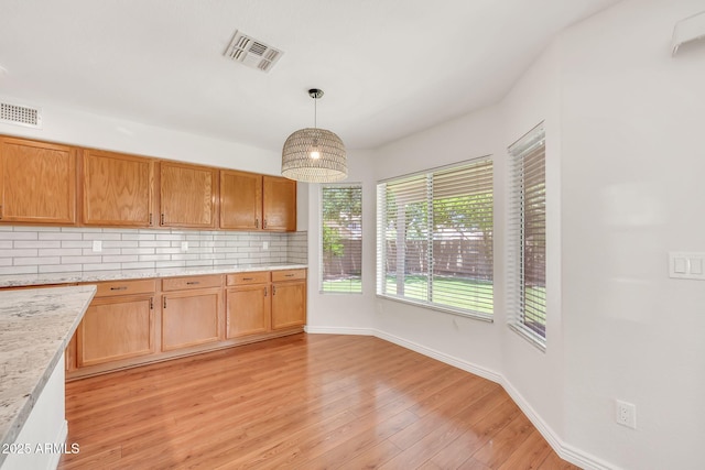 664 E Windsor Dr, Gilbert, AZ 85296 - kitchen with backsplash, light wood-style floors, baseboards, pendant lighting, and light stone countertops