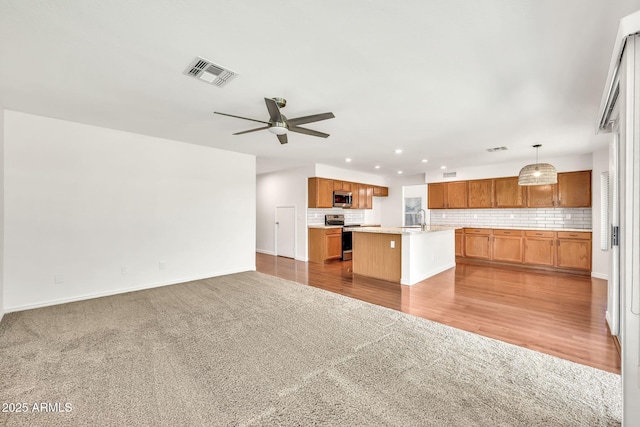 664 E Windsor Dr, Gilbert, AZ 85296 - kitchen with open floor plan, stainless steel appliances, carpet floors, light countertops, and a ceiling fan